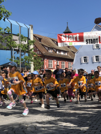 Gruppe von Kindern in gelben Trikots in vollem Lauf beim Waiblinger Stadtlauf