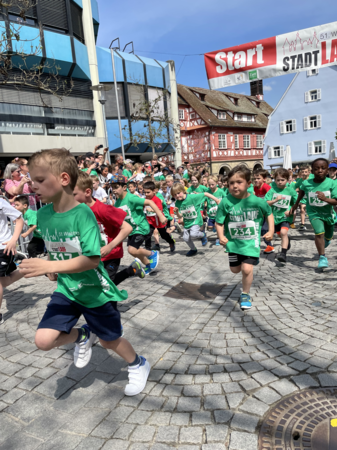 Gruppe von Kindern in grünen Trikots in vollem Lauf beim Waiblinger Stadtlauf