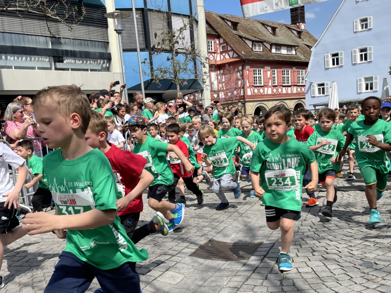 Gruppe von Kindern in grünen Trikots in vollem Lauf beim Waiblinger Stadtlauf